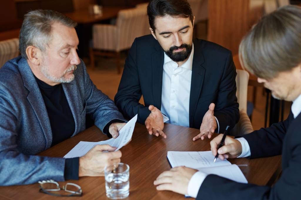 Business owners and attorneys reviewing commercial contracts, negotiating transaction terms, and managing legal agreements.