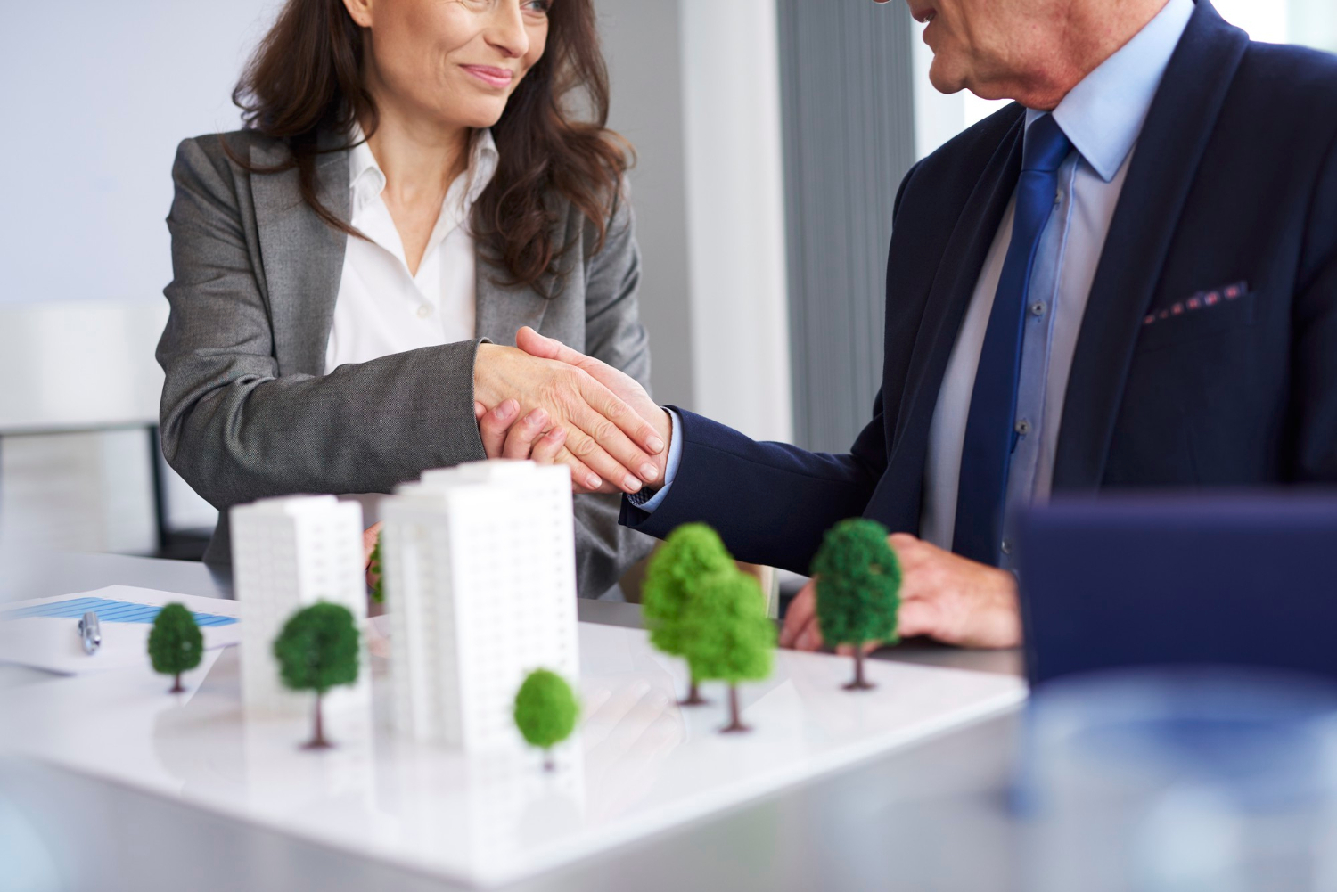 Commercial real estate attorney meeting with investors and business owners to review property acquisition and transaction documents.