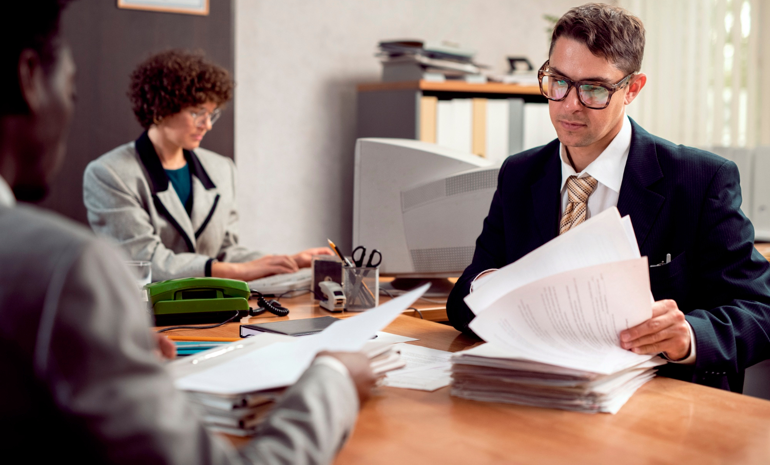 Business acquisition attorney reviewing financial records, contracts, and due diligence documents during a merger and acquisition transaction.