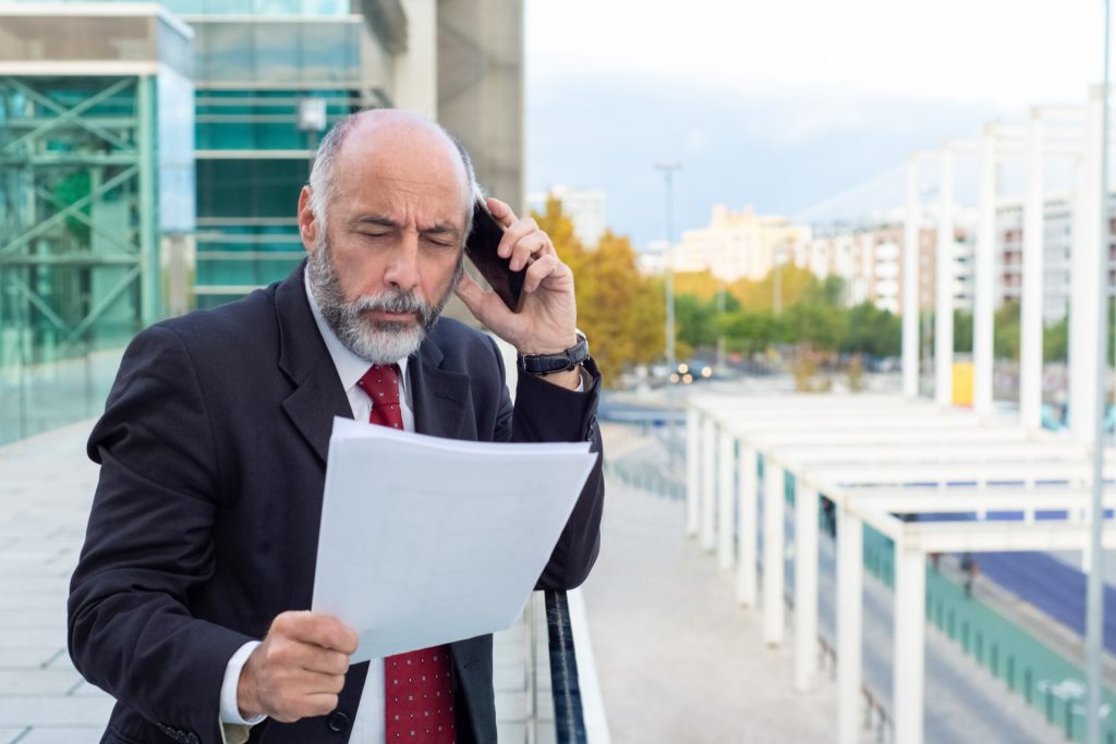 Business owner and attorney reviewing confidentiality agreements and trade secret safeguards